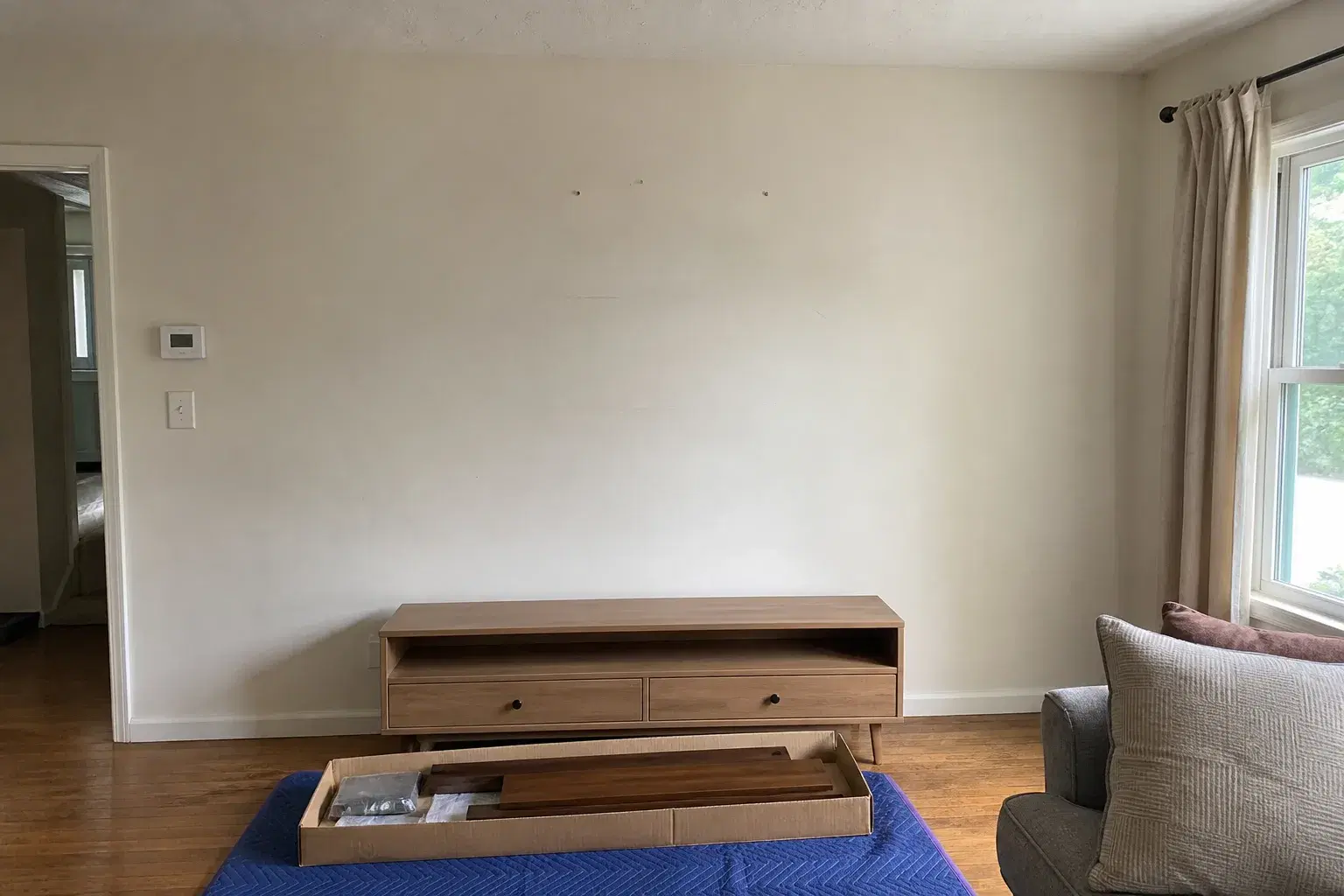 Living room wall and boxed shelf materials before a floating shelf installation